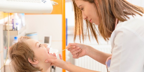 an emergency room nurse checks a child's throat in Houston, TX