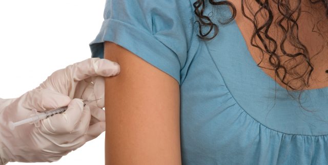 Doctor injects in females's hand.