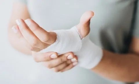 A person touching their bandaged hand at an emergency room in Houston, TX