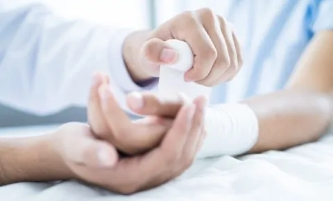 A doctor wraps a patient's wrist at an emergency room in Houston, TX