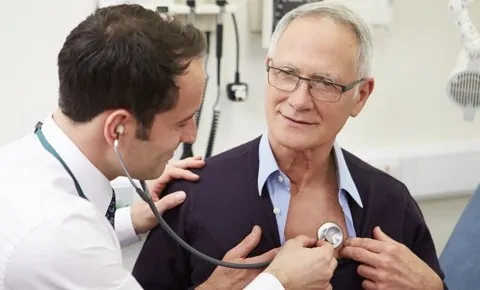 A doctor checking a patient's heart at an emergency room in Houston, TX