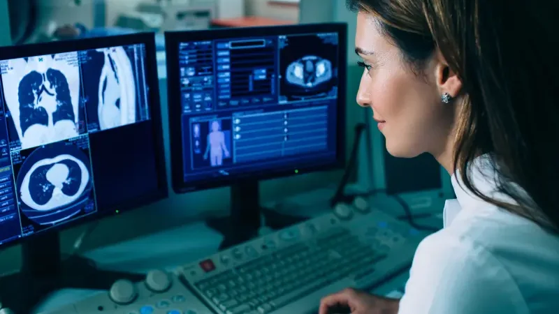 A doctor reviews a CT scan on a computer monitor in Houston, TX