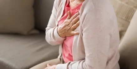 A woman clutching her chest in pain in Houston, TX